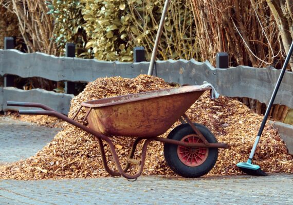 Gardening tools with wheelbarrow and broom used in professional landscape design services