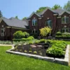 A professionally designed landscape with a variety of plants, trees, and mulch in a backyard in Rochester Hills, Michigan.