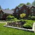 A professionally designed landscape with a variety of plants, trees, and mulch in a backyard in Rochester Hills, Michigan.